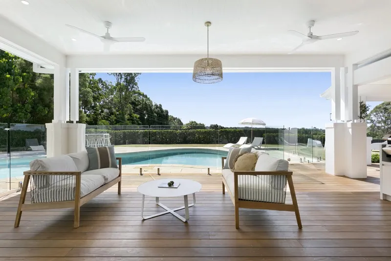 Tallebudgera Homestead - Warm timber decking and white pillars anchoring the modern pavilion